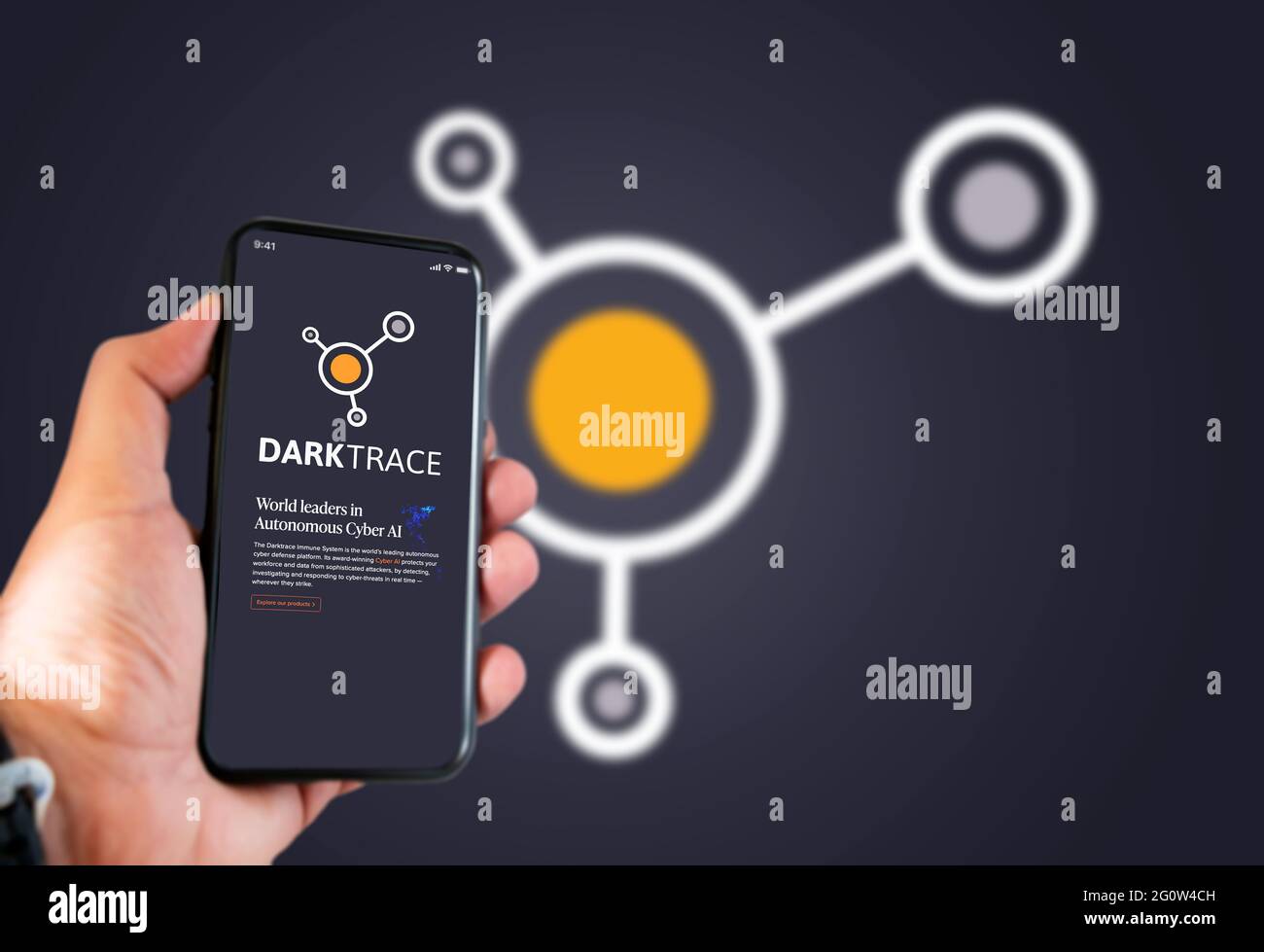 Cambridge, UK, maggio 2021: Una mano che tiene un telefono con il logo della società Darktrace sullo schermo. Darktrace è una società di intelligenza artificiale specializzata in cyber de Foto Stock