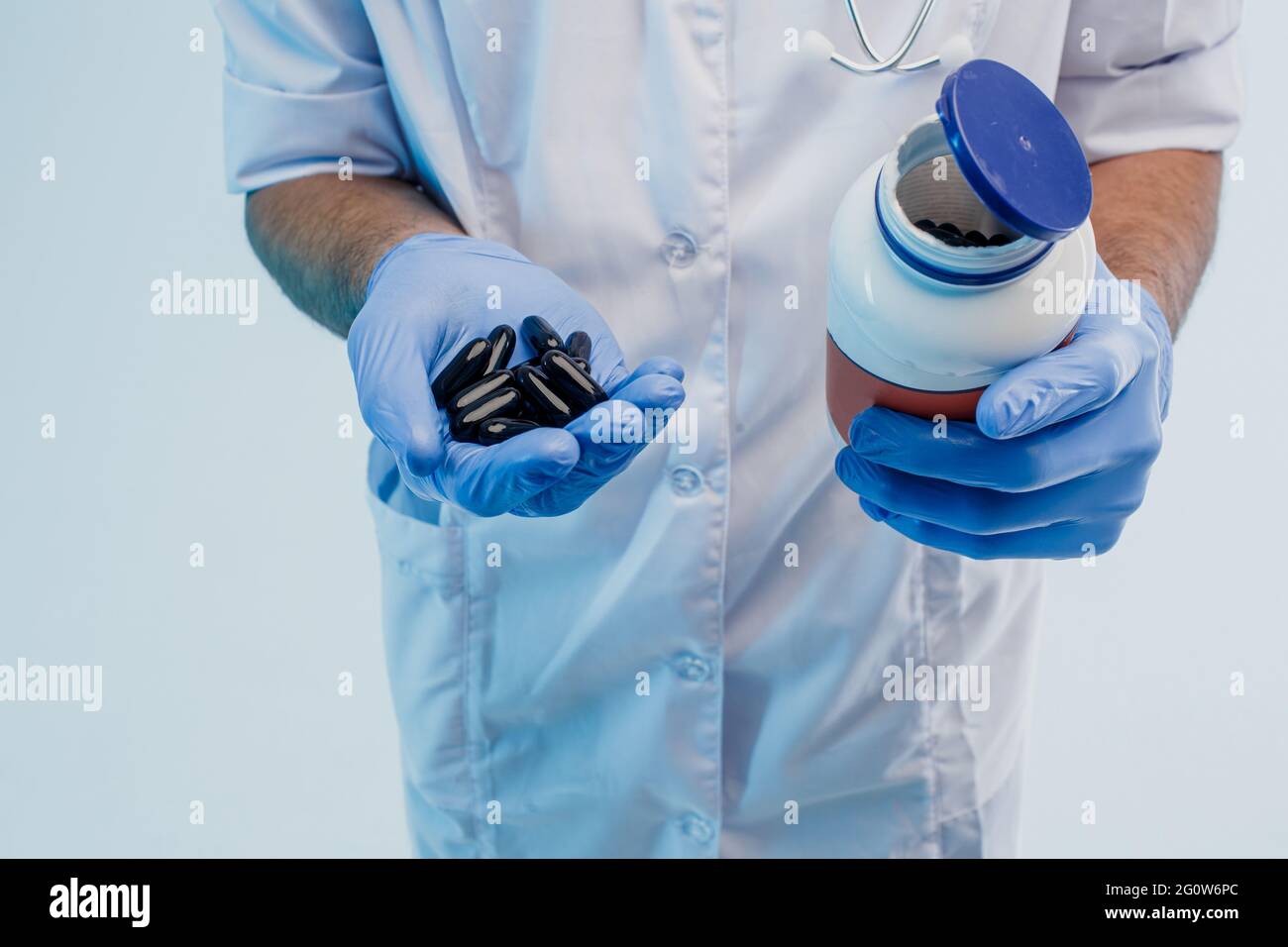 Mani di medico maschio che tengono una bottiglia di pillole Foto Stock