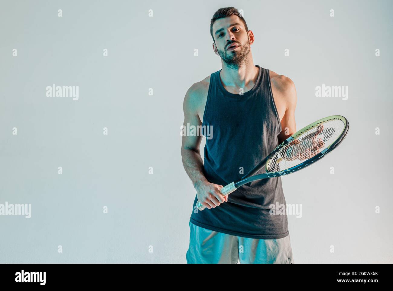 Fidato tennista maschile in posa con racchetta Foto Stock