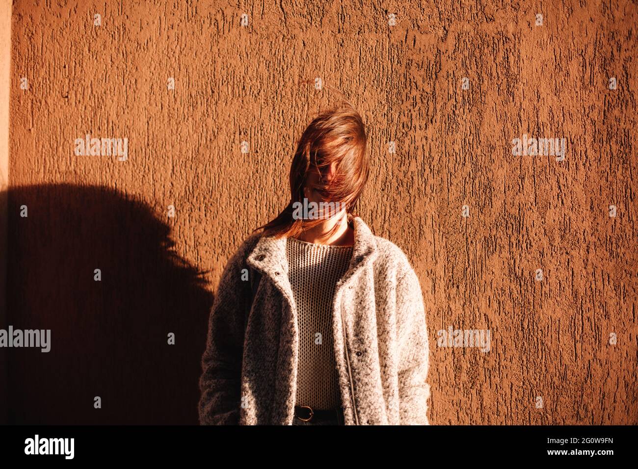 Ritratto di donna non binaria in piedi contro il muro in città Foto Stock