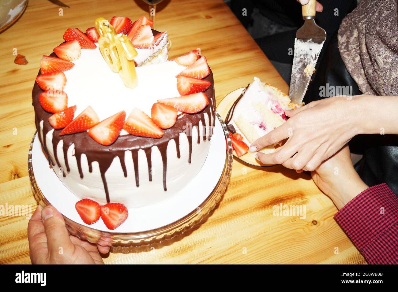 Una donna taglia una torta di compleanno e la mette in piattini