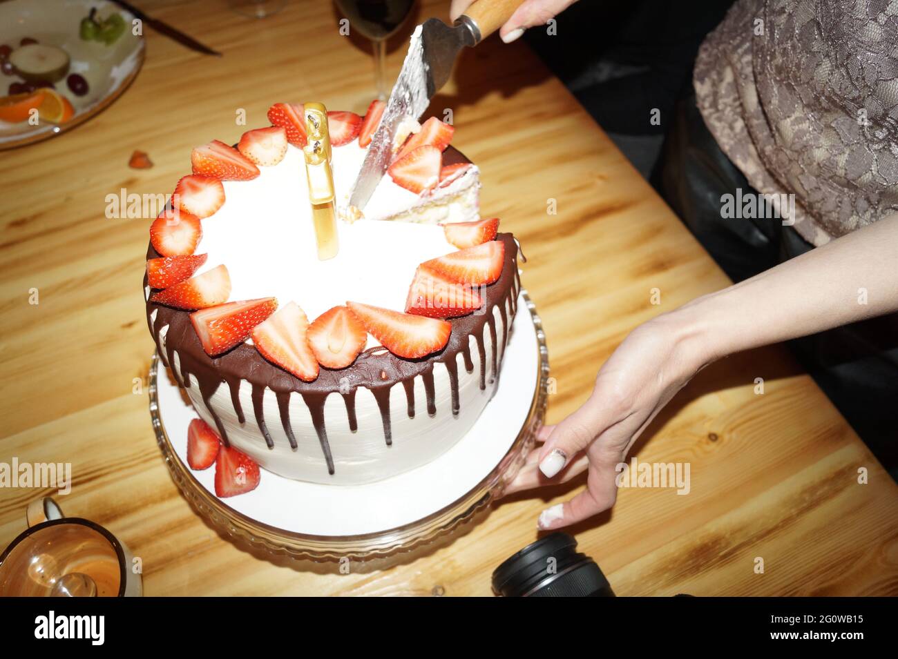 Una donna taglia una torta di compleanno e la mette in piattini Foto stock  - Alamy