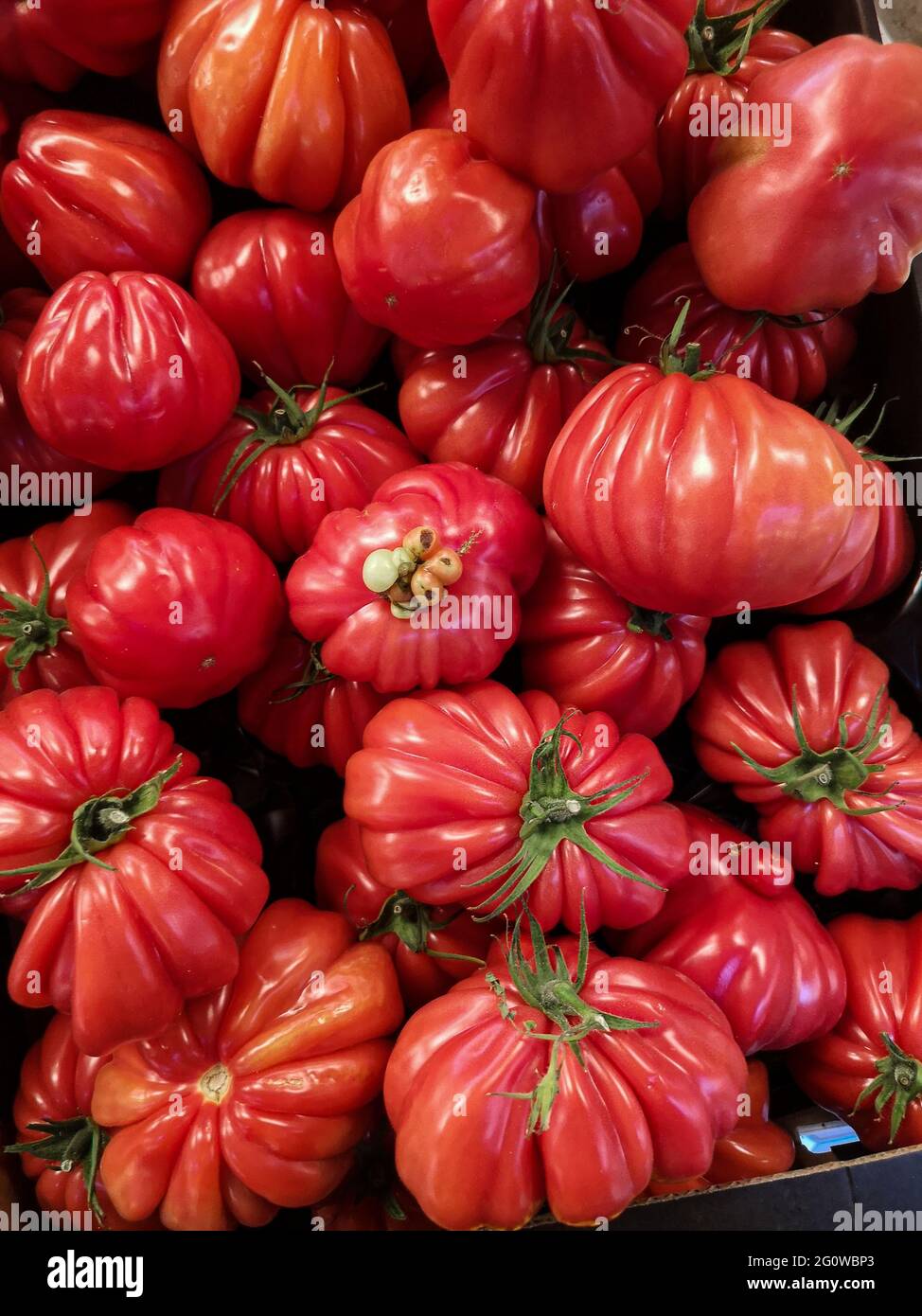 Una scatola di pomodori a coste sul mercato, macro foto Foto Stock