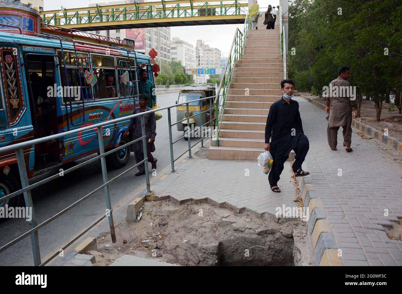 Pakistan. 3 giugno 2021: I pendolari passano attraverso una vicina rete fognaria aperta buco principale vicino Pedestrian Bridge che può causare qualsiasi incidente, soprattutto nelle ore notturne, mostrando la negligenza dei reparti interessati, situato sulla strada Shahrah-e-Faisal a Karachi giovedì 03 giugno 2021. Credit: Asianet-Pakistan/Alamy Live News Foto Stock