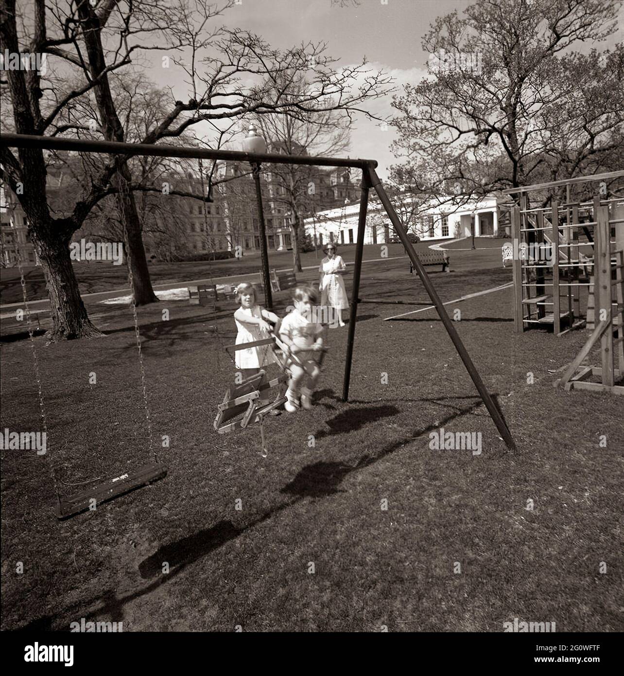 ST-C66-14-63 1 aprile 1963 Caroline Kennedy e John F. Kennedy Jr. Giocano su un altalenato. South Lawn, White House, Washington, D.C. si prega di credito 'Cecil Stoughton. Fotografie della Casa Bianca. John F. Kennedy Presidential Library and Museum, Boston' Foto Stock