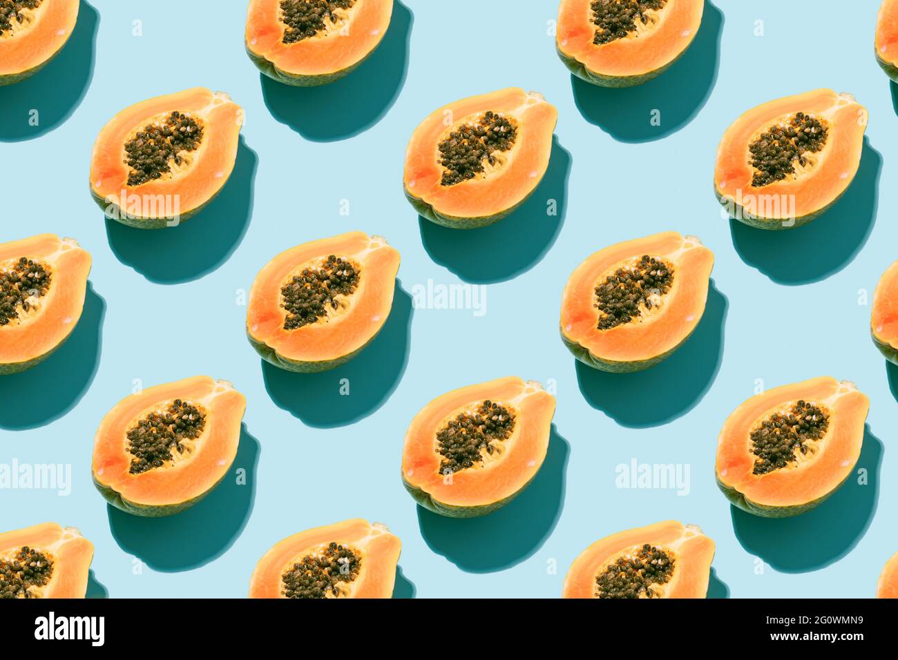 disegno creativo con frutta fresca di papaia con semi neri su sfondo blu. concetto di vacanza, estate e natura. vista dall'alto. Foto Stock
