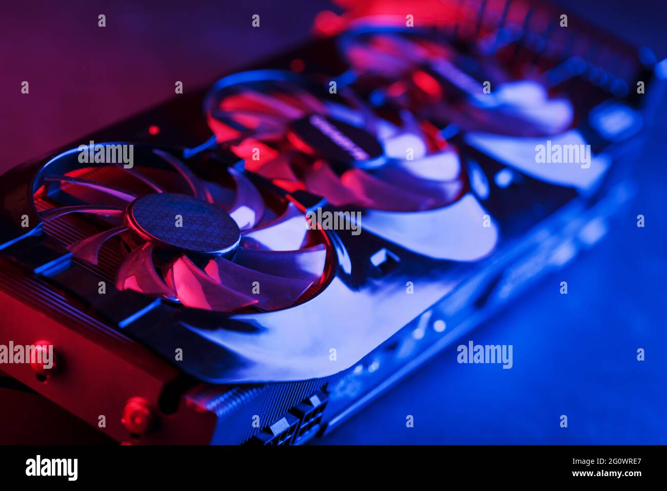 Una scheda grafica con una fila di fan con retroilluminazione cianoica viola in un design futuristico. Potente scheda grafica per videogiochi e cryptocu Foto Stock