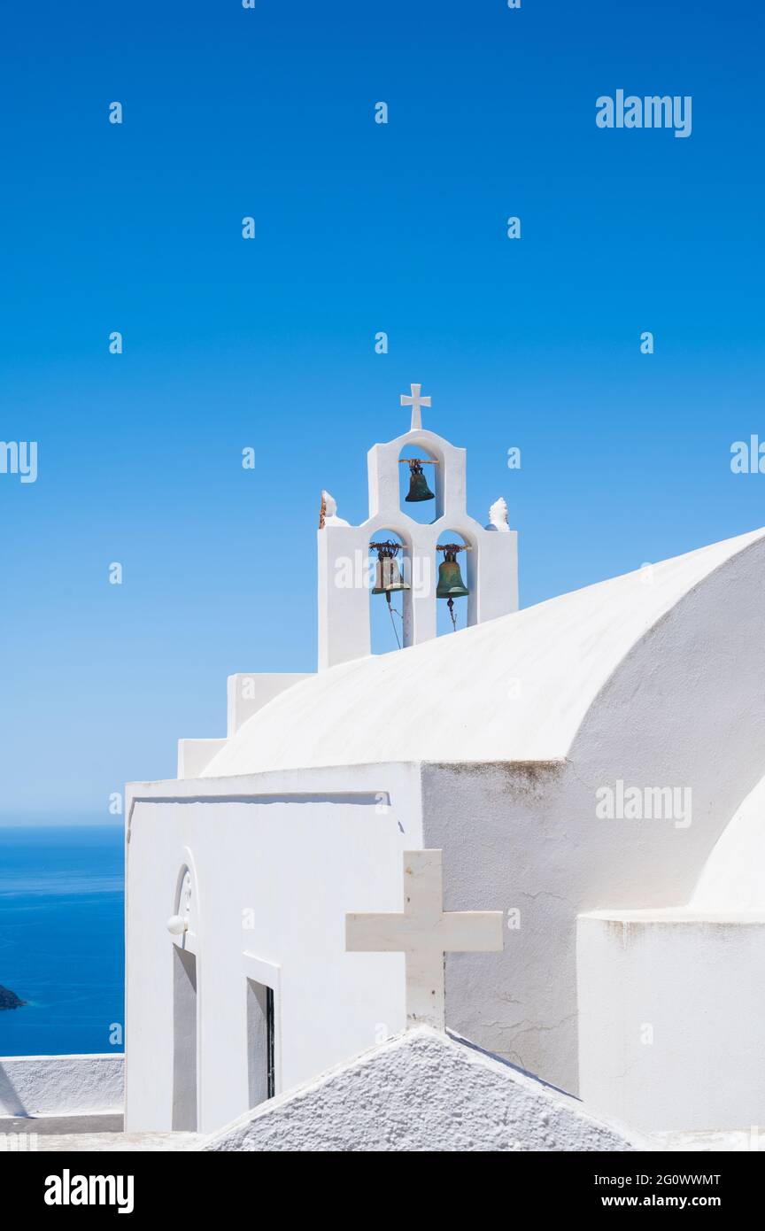 Il campanile bianco della tradizionale chiesa greco-ortodossa sull'isola di Santorini. Cielo blu su sfondo. Foto Stock