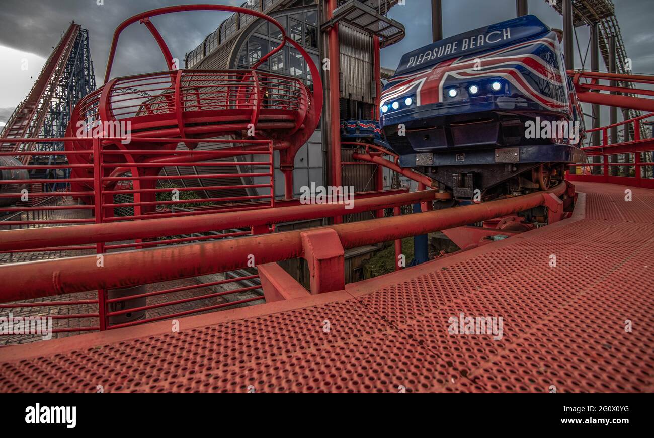 Un treno parte dalla stazione prima di arrampicarsi sulla collina di Lift Hill a Blackpool Pleasure Beach, la Big One Rollercoaster Foto Stock