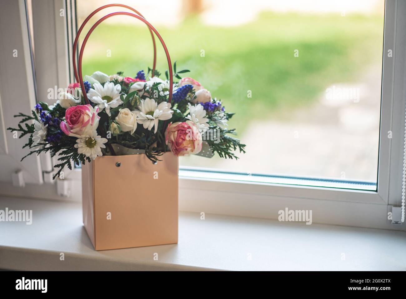 Bouquet di fiori diversi in borsa di carta con maniglie in piedi su un  davanzale Foto stock - Alamy