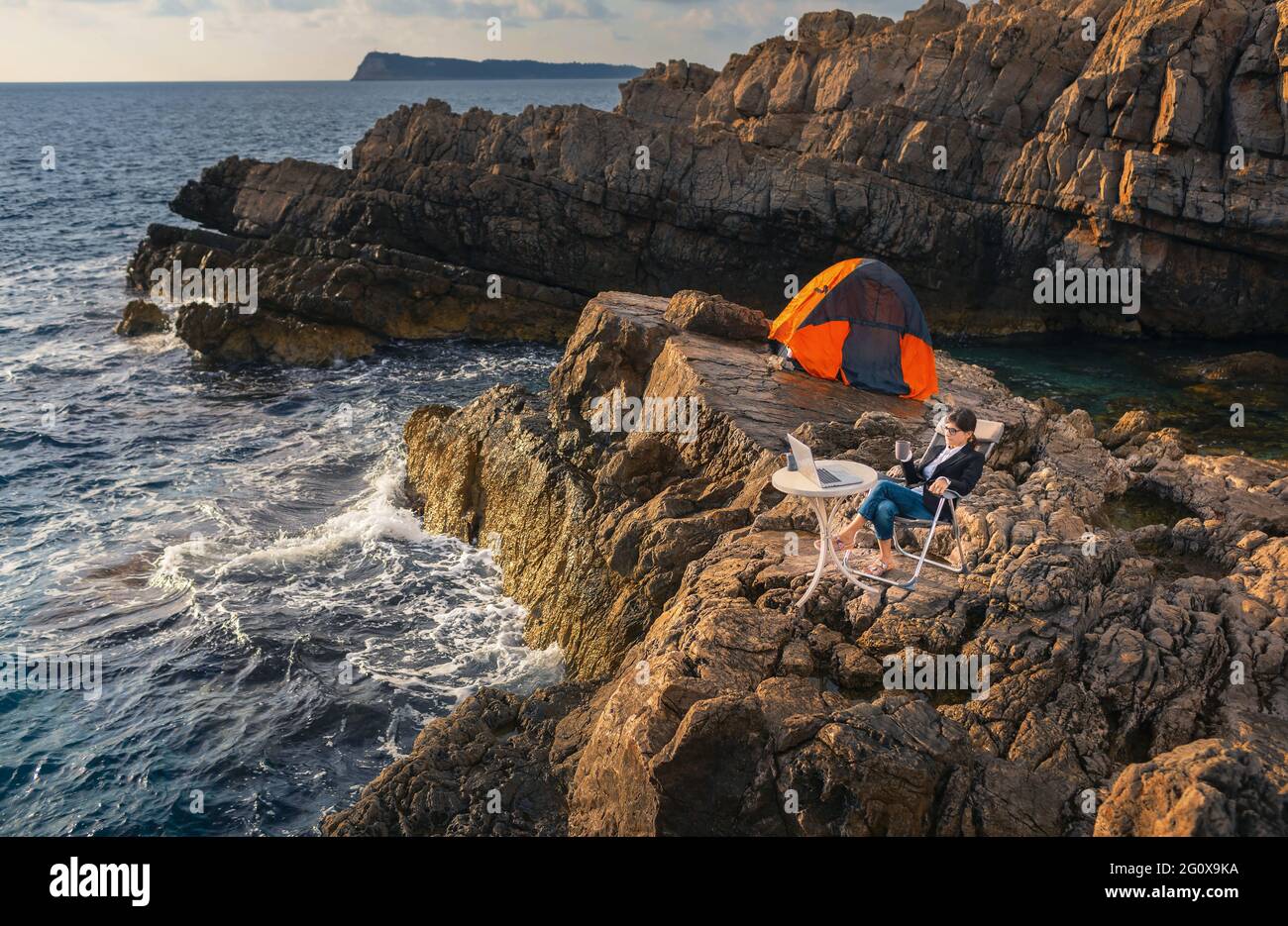 Donna d'affari che lavora dalla spiaggia. Concetto di lavoro a distanza. Freelance viaggi e lavoro online. Foto Stock