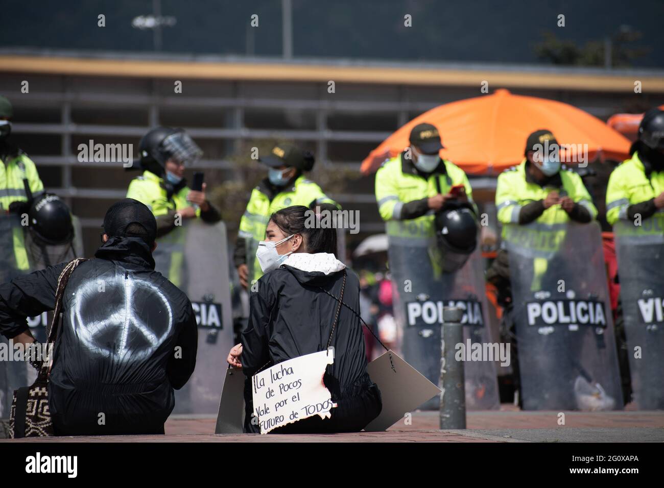 Bogotà, Colombia. 02 giugno 2021. Con la polizia alle sue spalle, un manifestante tiene un segno che recita 'la lotta di tutti per i valori di tutti'. In un nuovo giorno di protesta anti-governo a Bogotá, Colombia contro il governo del presidente Iván Duque e la brutalità della polizia il 2 giugno 2021 Credit: Long Visual Press/Alamy Live News Foto Stock