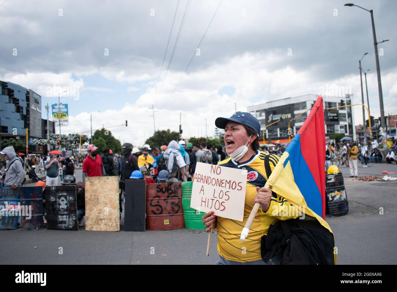 Bogotà, Colombia. 02 giugno 2021. Un manifestante davanti alla cosiddetta prima linea, con una camicia colombiana, ha un segno che dice 'non abbandoniamo i nostri figli' in un nuovo giorno di protesta a Bogotá, nel contesto di uno sciopero nazionale in Colombia contro il governo del presidente Iván Duque il 2 giugno; 2021 credito: Long Visual Press/Alamy Live News Foto Stock