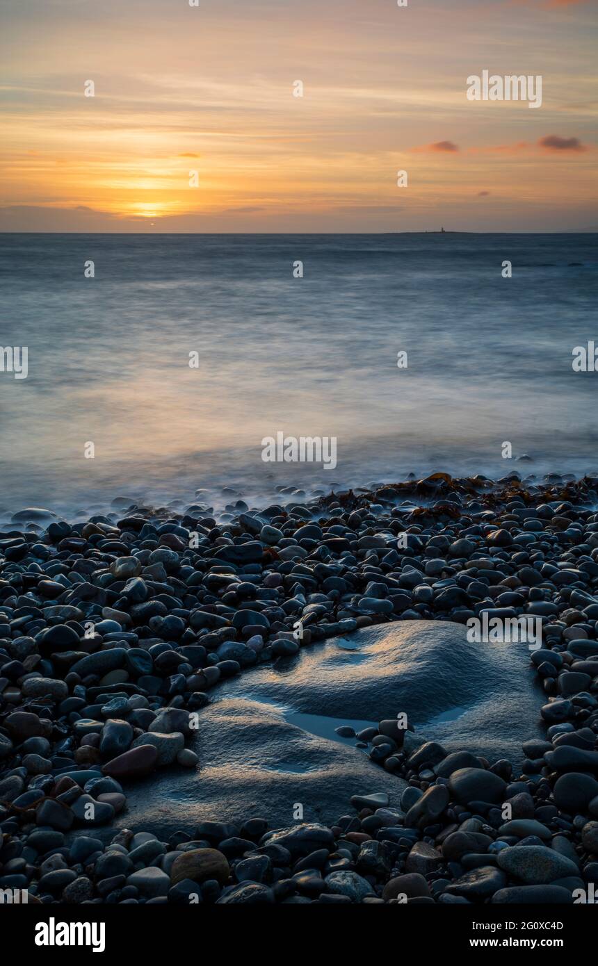 Un colorato tramonto sull'oceano dalla riva di Troon nel Sud Ayrshire, Scozia. Foto Stock
