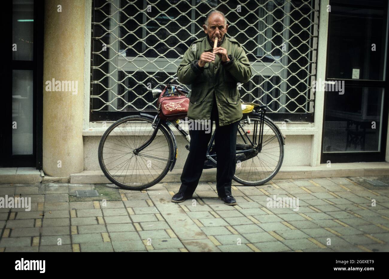 Ein ALTER Flötenspieler in einer Straße der geteilten Hauptstadt von Zypern, Nikosia - un vecchio che gioca il suo flauto su una strada della capitale divisa di Cipro, Nicosia. Foto Stock