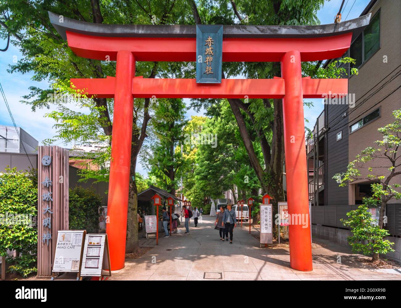 tokyo, giappone - Maggio 03 2019: Turisti che camminano tra le lanterne di legno sotto il grande portale del vermiglio Torii del santuario shintoista Akagi progettato da Foto Stock