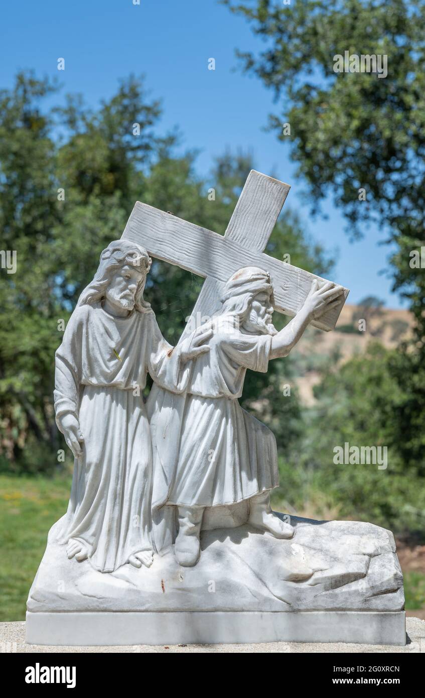 Santa Inez, CA, USA - 3 aprile 2009: Seminario di San Lorenzo. Stazione della Croce numero 5 statua in marmo bianco. Simone di Cirene aiuta Gesù. In blu Foto Stock