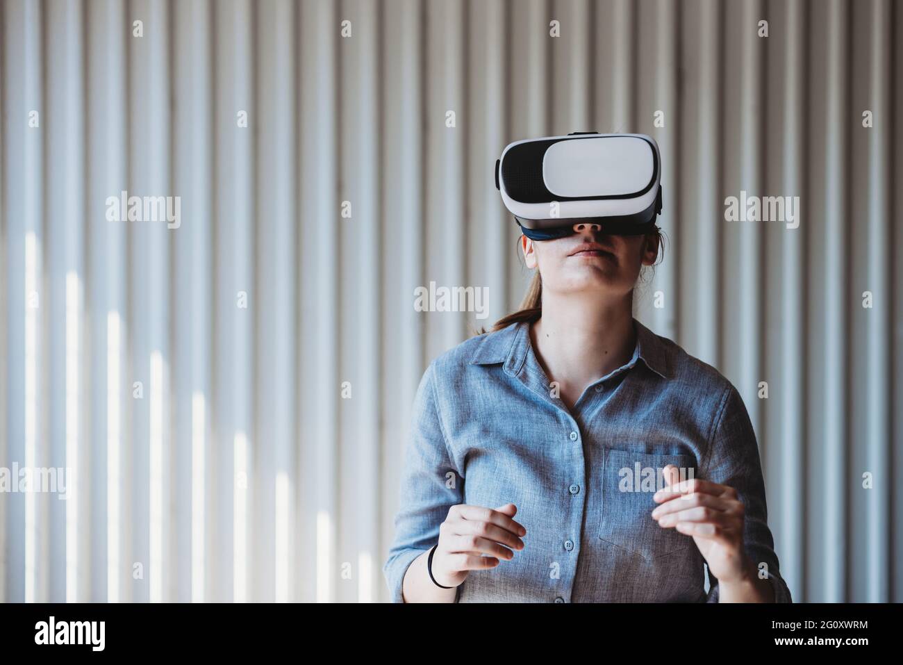 donna con occhiali di protezione vr che gode di un'esperienza di realtà virtuale Foto Stock