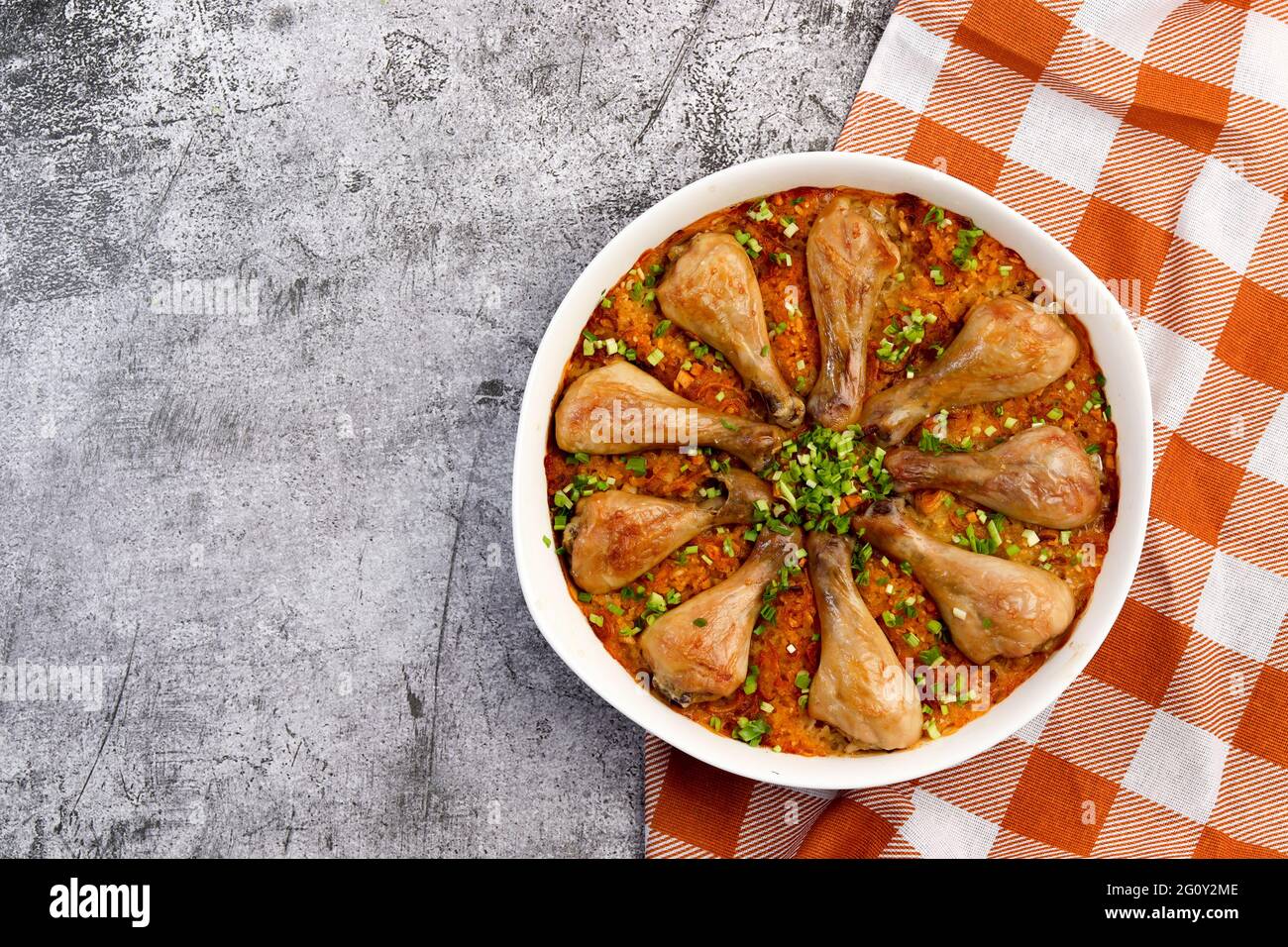 Bastoncini di pollo al forno e riso con in una teglia bianca su sfondo grigio scuro. Vista dall'alto, disposizione piatta Foto Stock