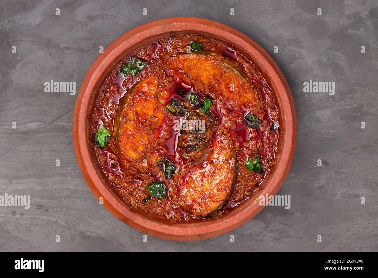 SeerFish o KingFish curry, curry tradizionale indiano di pesce, kerala stile o kottayam piatto di stile, organizzato in una terrena guarnita con curry lasciare Foto Stock