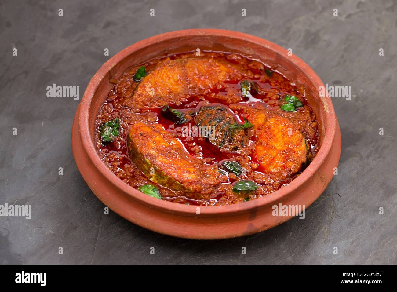 SeerFish o KingFish curry, curry tradizionale indiano di pesce, kerala stile o kottayam piatto di stile, organizzato in una terrena guarnita con curry lasciare Foto Stock