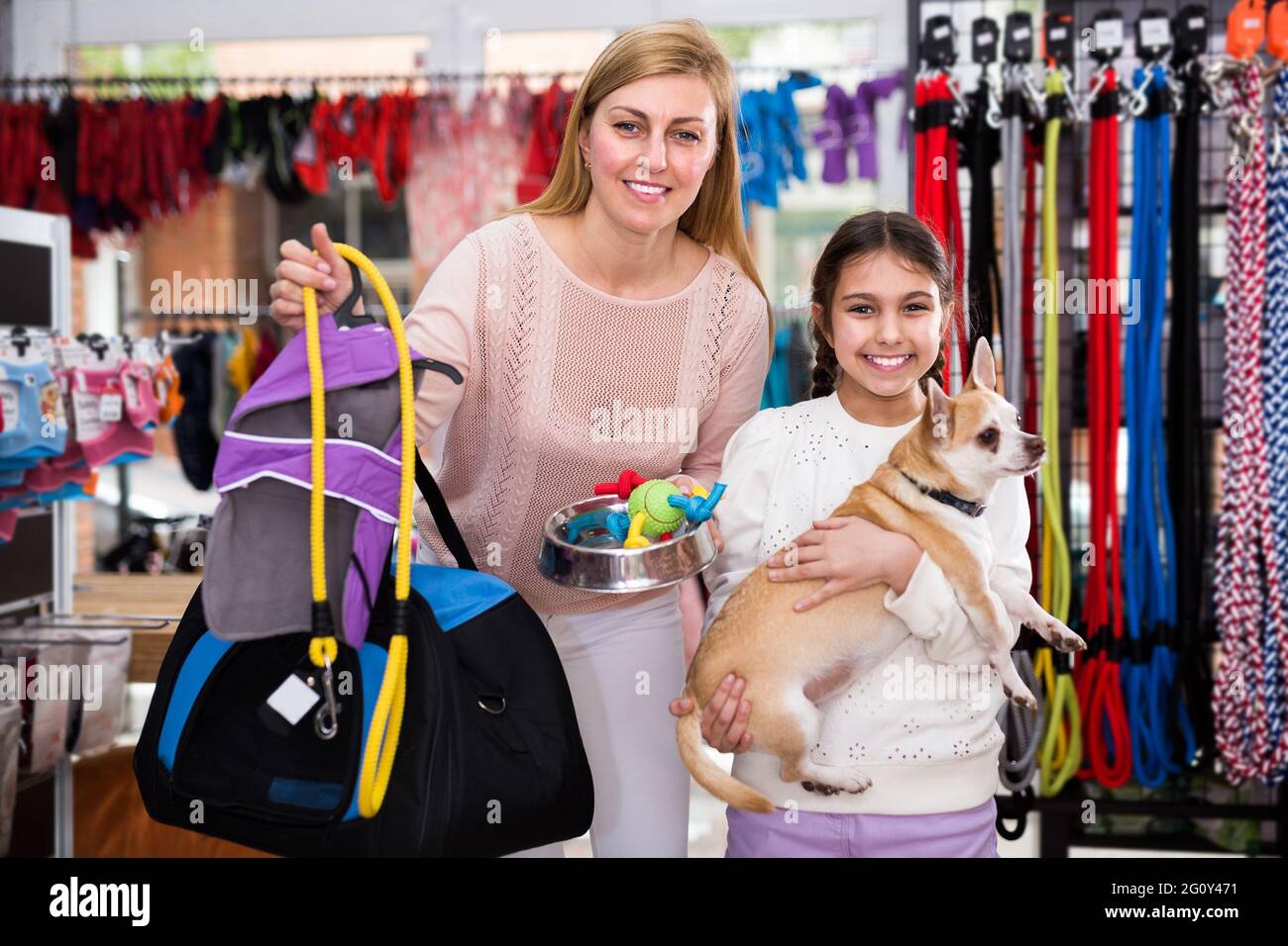 Ragazza carina con la sua madre positiva e il cane nel negozio di animali  domestici Foto stock - Alamy