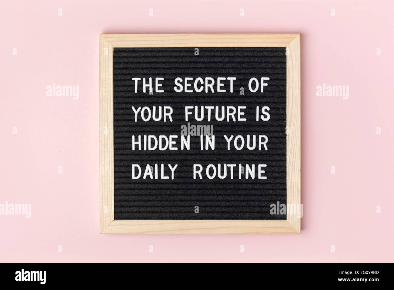 Il segreto del vostro futuro è nascosto nella vostra routine quotidiana. Citazione motivazionale su bordo nero della lettera su sfondo rosa. Citazione ispiratrice del concetto di Foto Stock