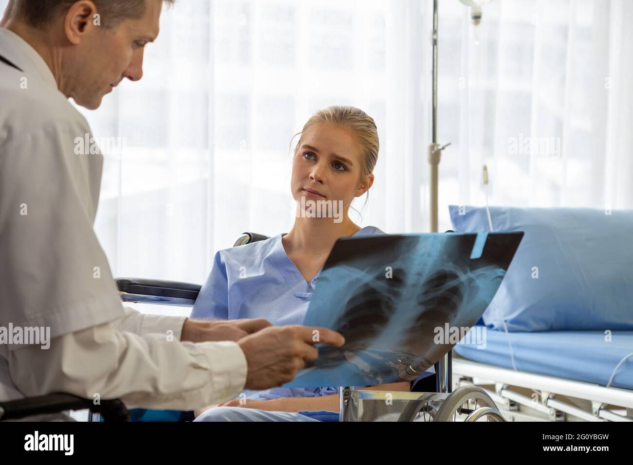 Medico che esamina la pellicola radiografica del torace della paziente in ospedale. Sindrome respiratoria o concetto di sintomo di polmonite virale Foto Stock