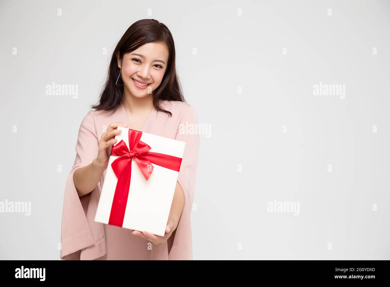 Felice bella donna asiatica sorriso con scatola regalo isolato su sfondo bianco. Ragazze adolescenti innamorate, che ricevono doni dagli amanti. Capodanno, Natale Foto Stock