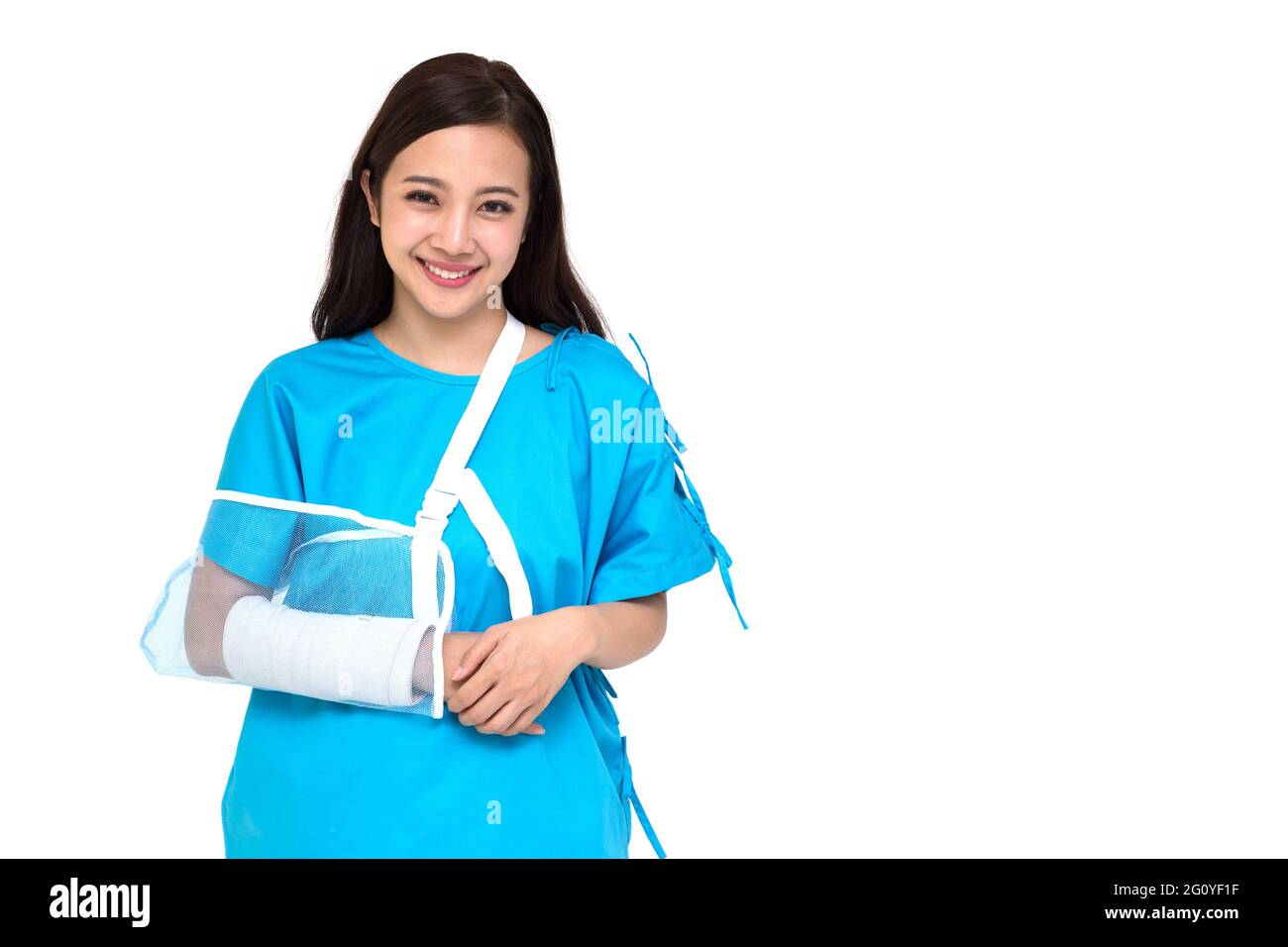 Giovane asiatico bella donna che indossa abiti paziente e mettere su una morbida splint a causa di un braccio rotto isolato su sfondo bianco, incidente personale conce Foto Stock