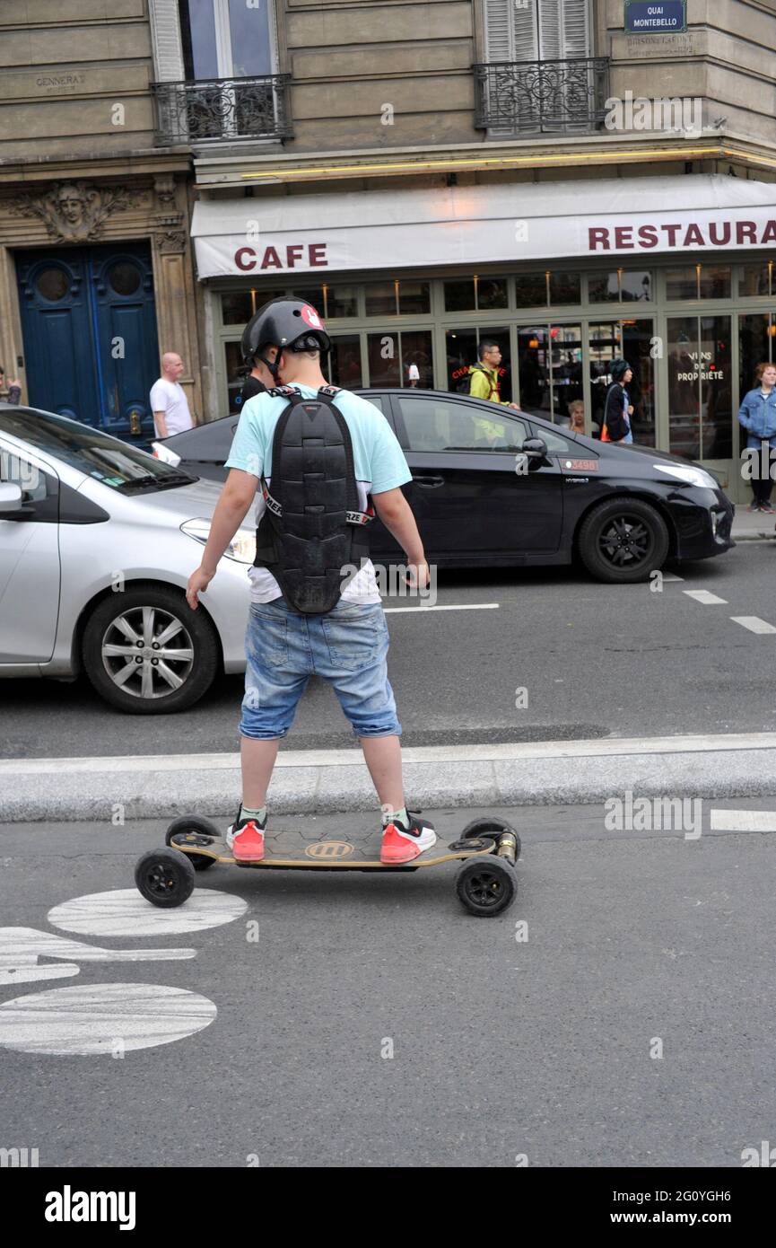 FRANCIA. PARIGI (75) GIOVANI SU UNA SKATE BOARD ELETTRICA IN UN INGORGO DI TRAFFICO Foto Stock