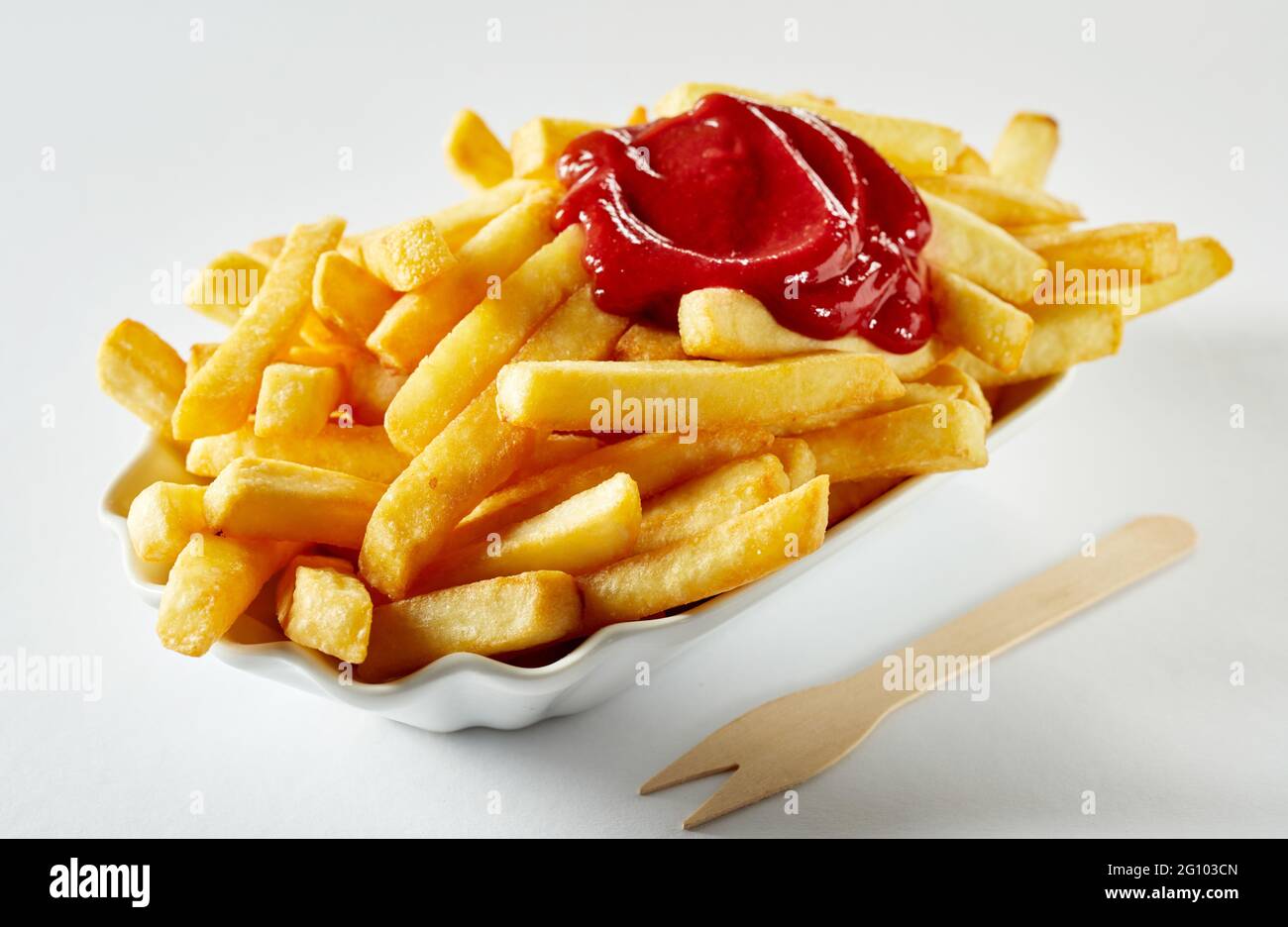 Appetitose patatine fritte con ketchup in ciotola di ceramica vicino al  bastone ecologico su sfondo bianco Foto stock - Alamy