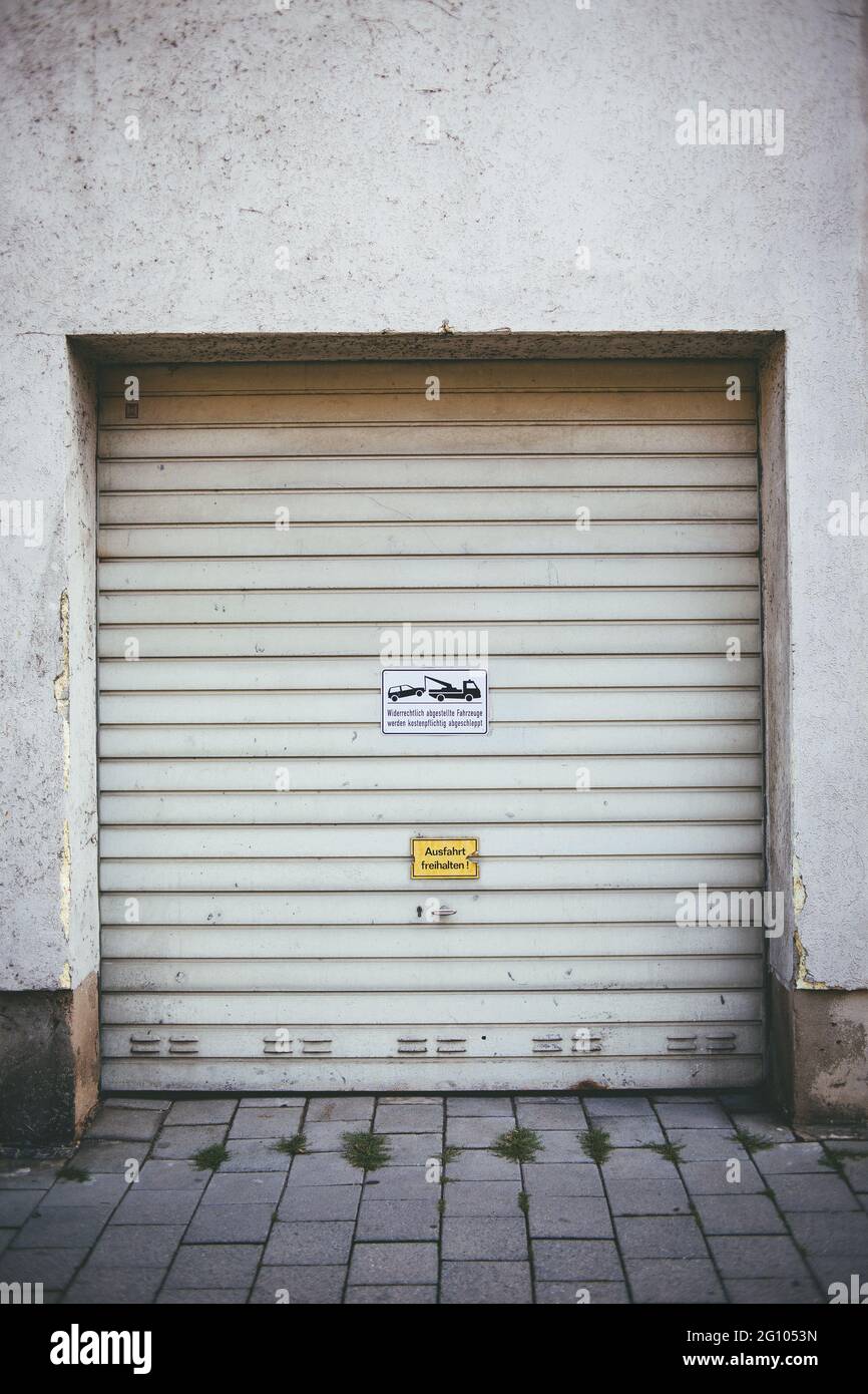 Immagine verticale della porta bianca del garage con cartelli - per sfondi Foto Stock