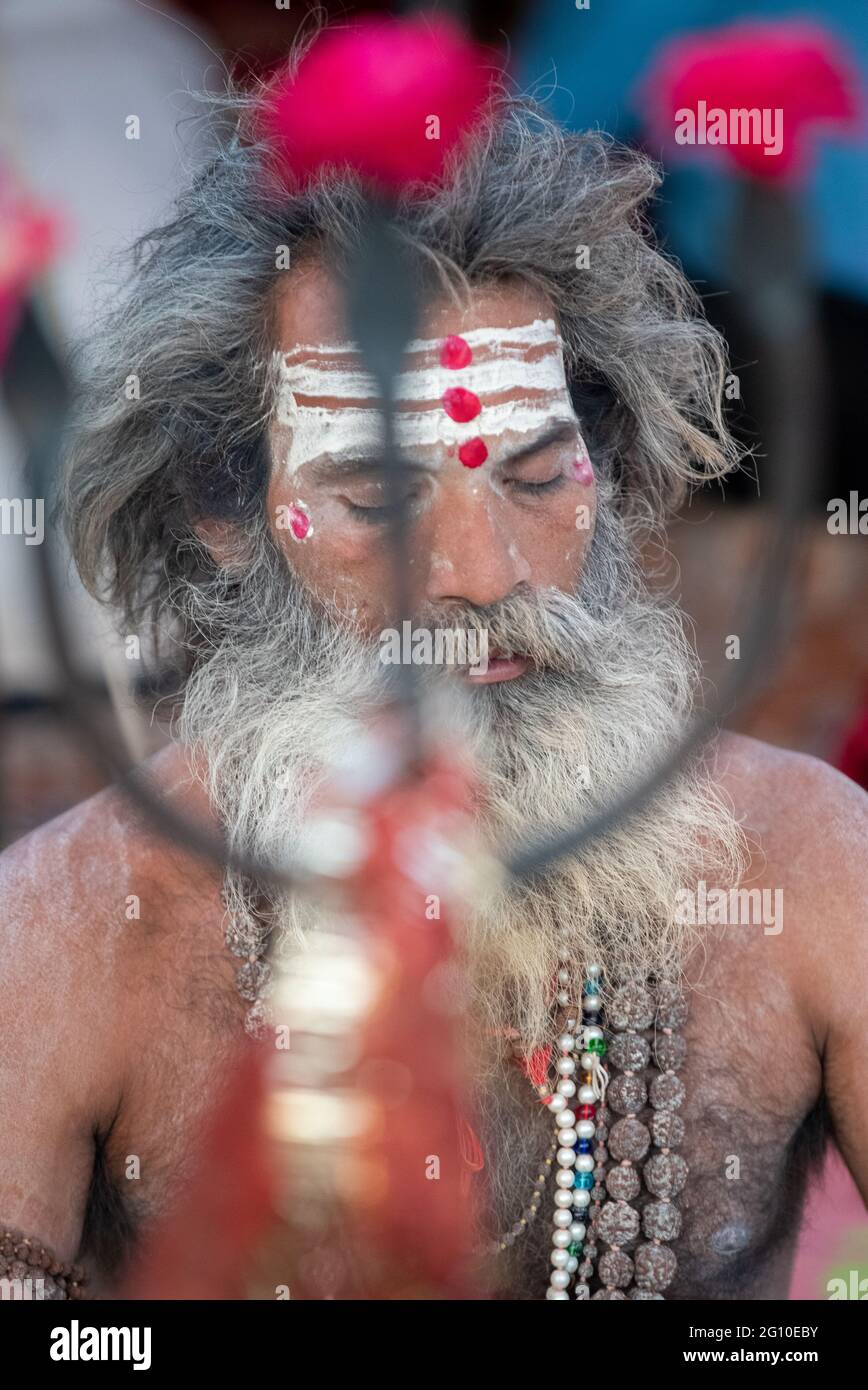 Haridwar, Uttarakhand, India 12 aprile 2021. I Santi Indiani nel loro modo tradizionale di YOG Mudra, meditando. Seduta in silenzio come parte dell'iniziazione di nuovo sadhus durante Kumbha Mela. Il Sadhus di Naga. Foto Stock