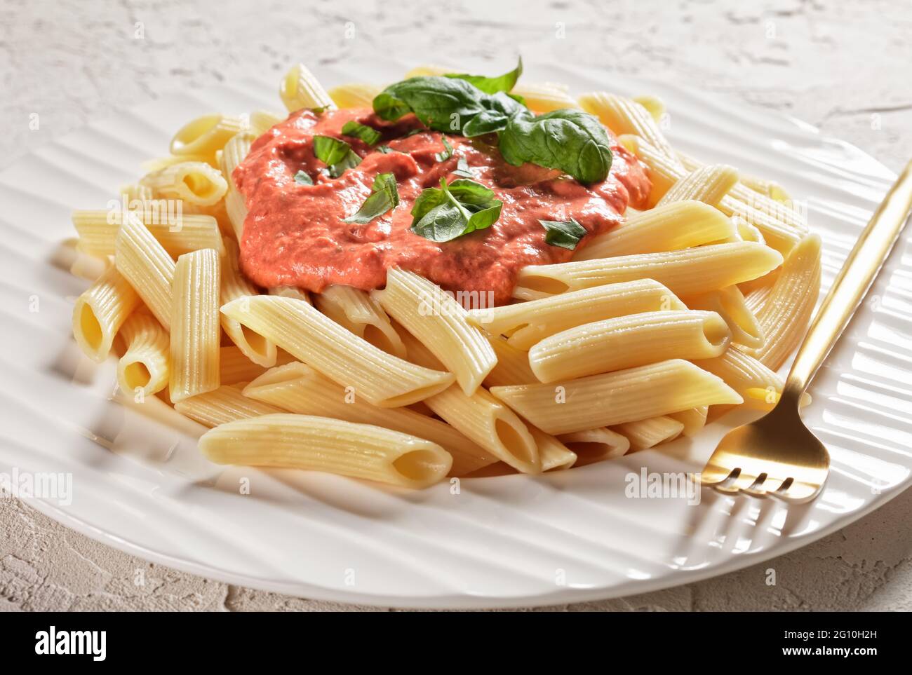 Salsa Rosa Pasta, salsa Rosa di Parma con penne su un piatto bianco con  forchetta dorata, primo piano Foto stock - Alamy