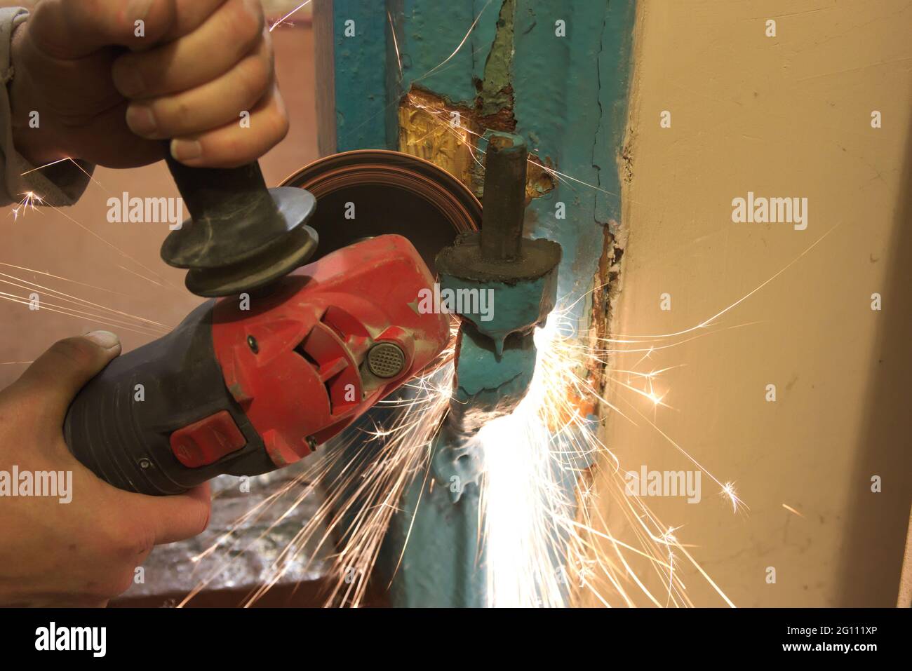Lavoratore il taglio di metallo con la fresa. Scintille volanti durante la macinazione di ferro Foto Stock