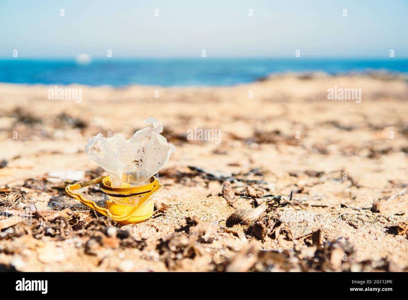 Primo piano di una bottiglia di plastica rotta sulla spiaggia - concetto di inquinamento marittimo e cambiamento climatico per responsabilità umana - sfondo sfocato Foto Stock