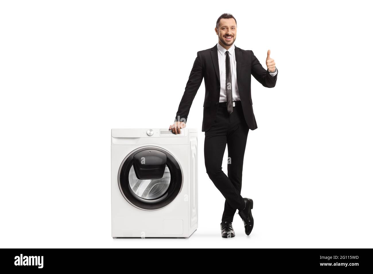 Ritratto a lunghezza intera di un uomo d'affari appoggiato su una lavatrice e mostrando pollici su isolato su sfondo bianco Foto Stock