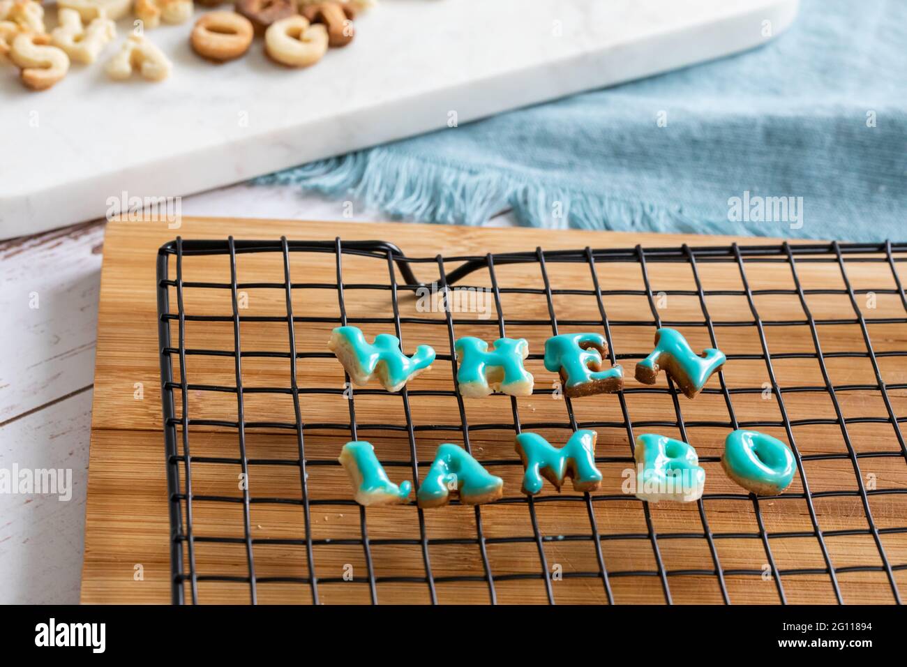 Quando lambo scritto in biscotti che asciugano su una griglia metallica su una tavola di legno con ghiaccio blu Foto Stock