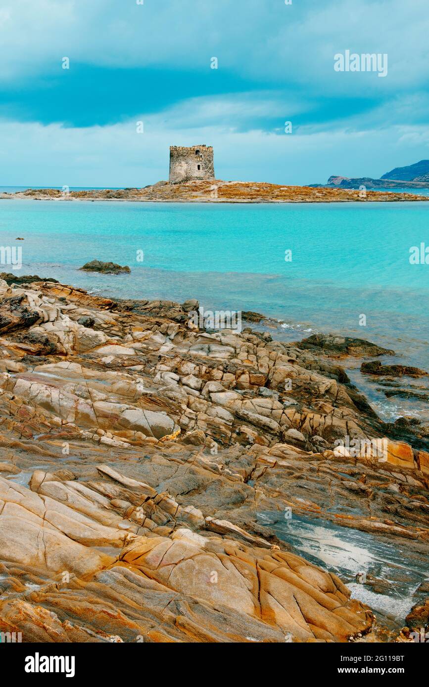 Vista di alcune formazioni rocciose sulla pittoresca spiaggia della Pelosa in Sardegna, Italia, con la Torre della Pelosa e l'Isola Pian Foto Stock