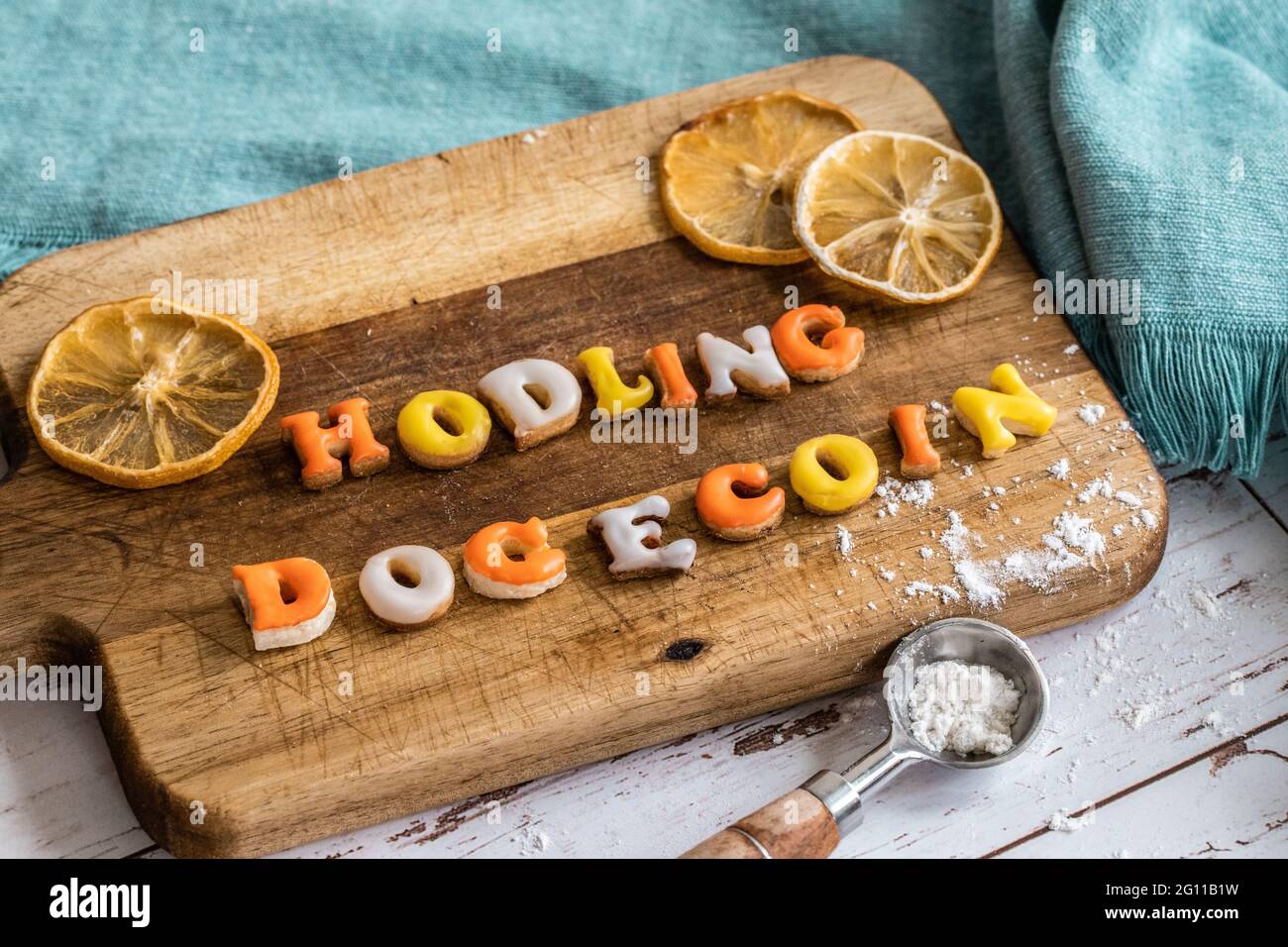 detto popolare nella comunità di valuta online frase fatta di giallo arancio e biscotti bianchi su un piatto di legno con un cucchiaio di misurazione e un Foto Stock