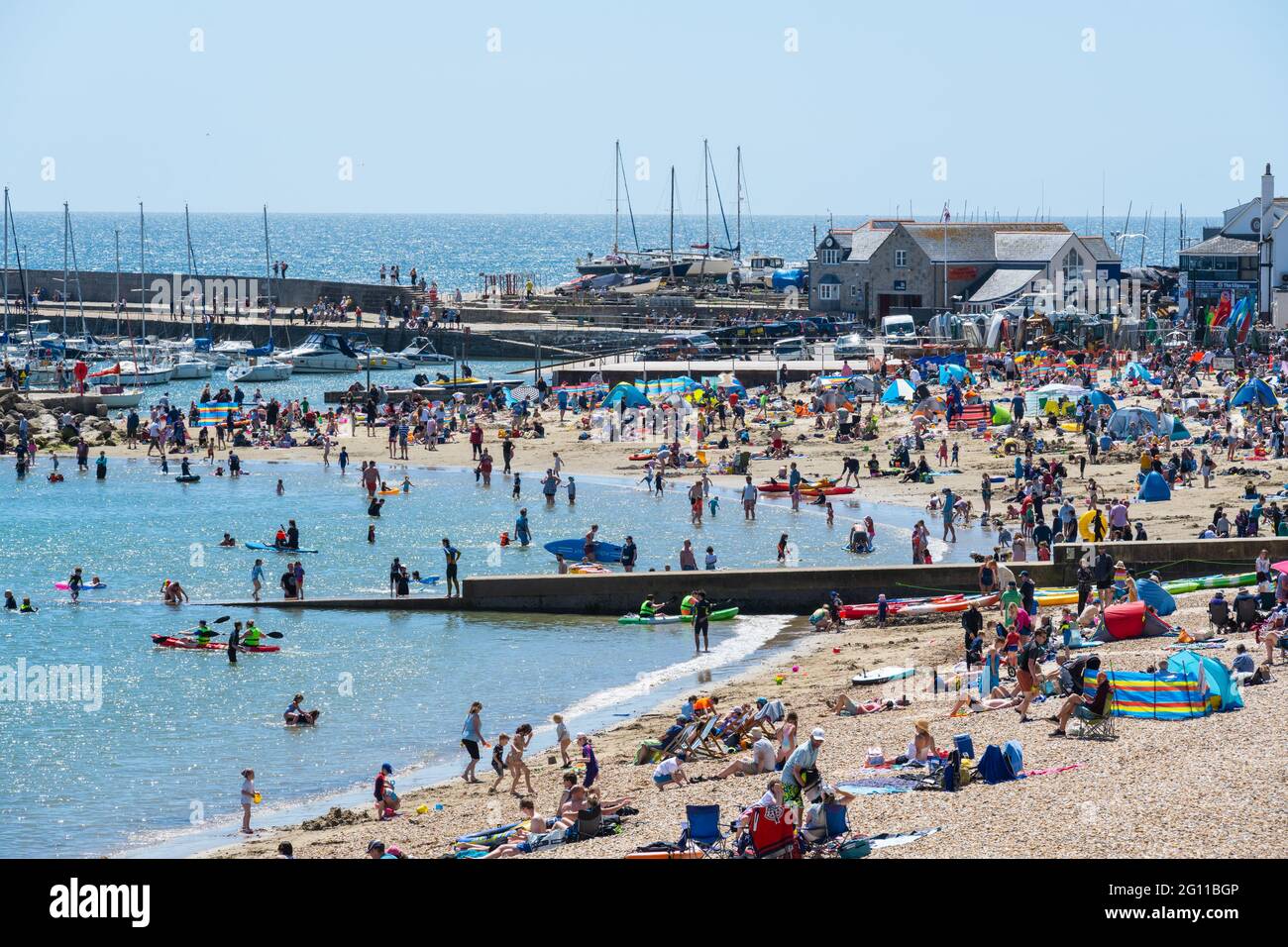 Lyme Regis, Dorset, Regno Unito. 4 Giugno 2021. Regno Unito Meteo: La bella spiaggia di Lyme Regis è stata piena di bagnanti e famiglie di nuovo il Venerdì pomeriggio come i vacanzieri ha assorbito il sole caldo glorioso sotto cielo blu chiaro. Gli Staycaakers stavano chiaramente facendo il la cosa migliore degli ultimi giorni di mezzo termine mentre le termperature hanno continuato a salire. Credit: Celia McMahon/Alamy Live News Foto Stock