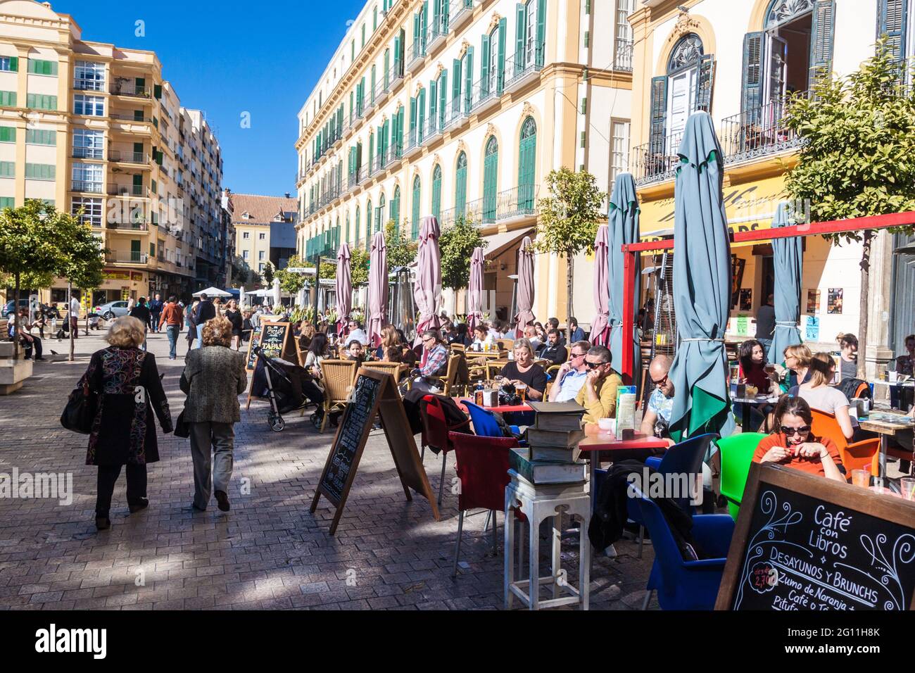 MALAGA, SPAGNA - 25 GENNAIO 2015: La gente siede nei caffè sulla piazza Plaza de la Merced a Malaga. Foto Stock