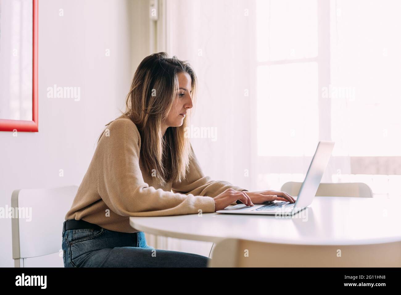 Italia, giovane donna che usa il laptop a casa Foto Stock