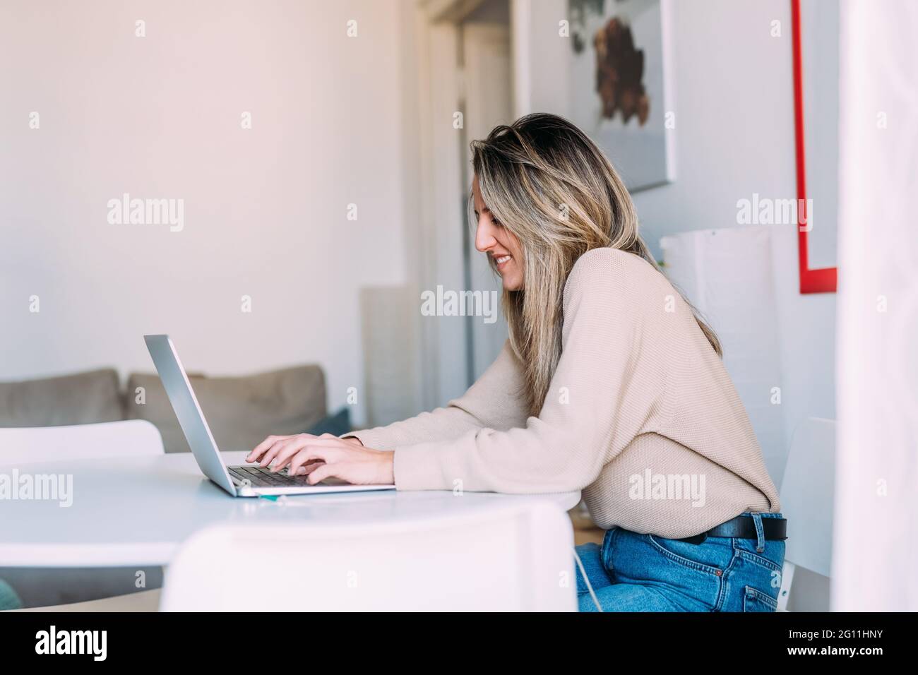 Italia, giovane donna che usa il laptop a casa Foto Stock