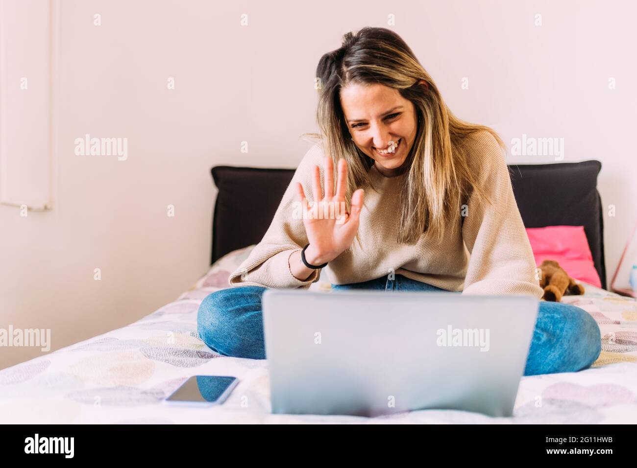 Italia, giovane donna che usa il computer portatile a letto Foto Stock