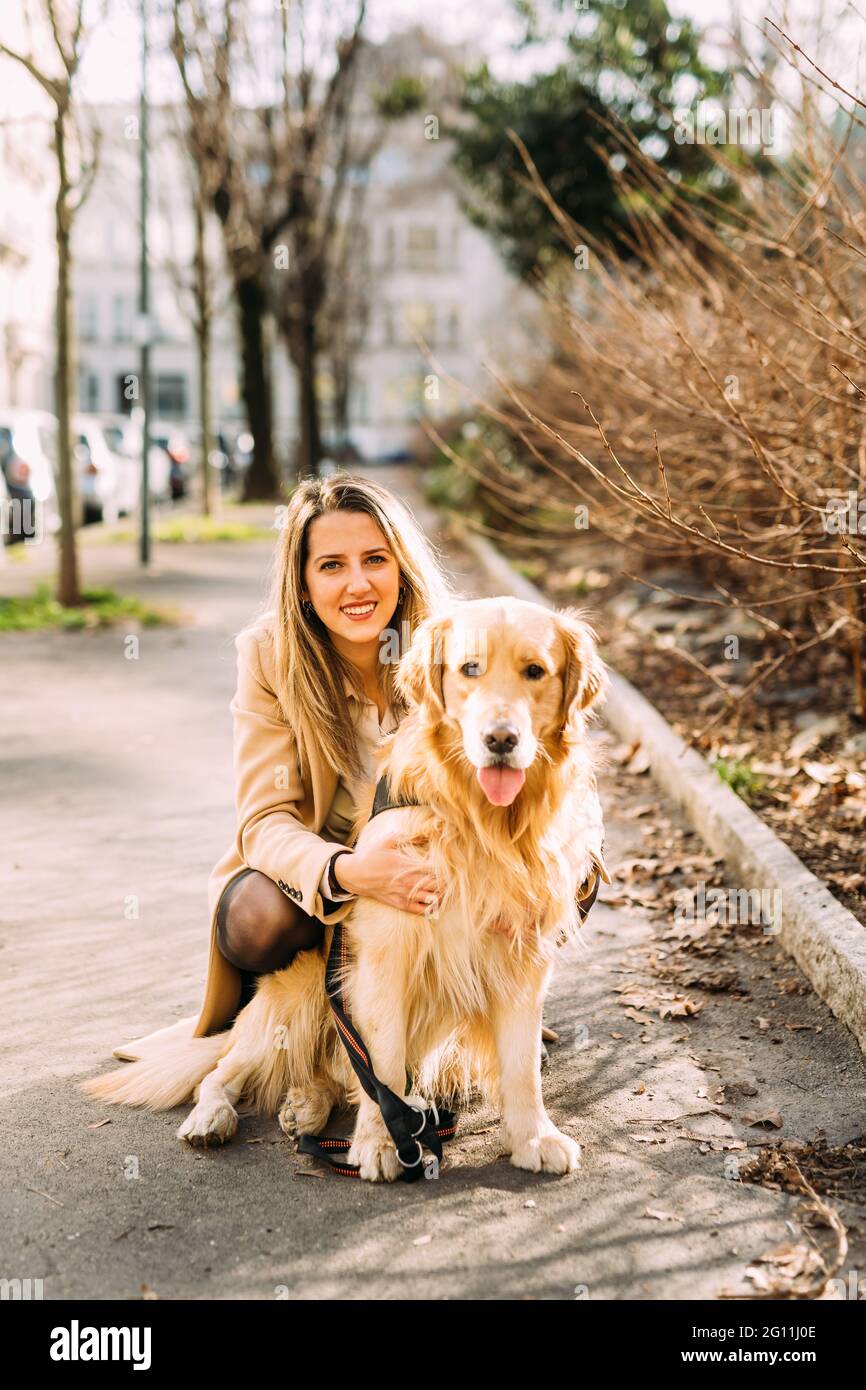 Italia, Ritratto di giovane donna con cane sul marciapiede Foto Stock