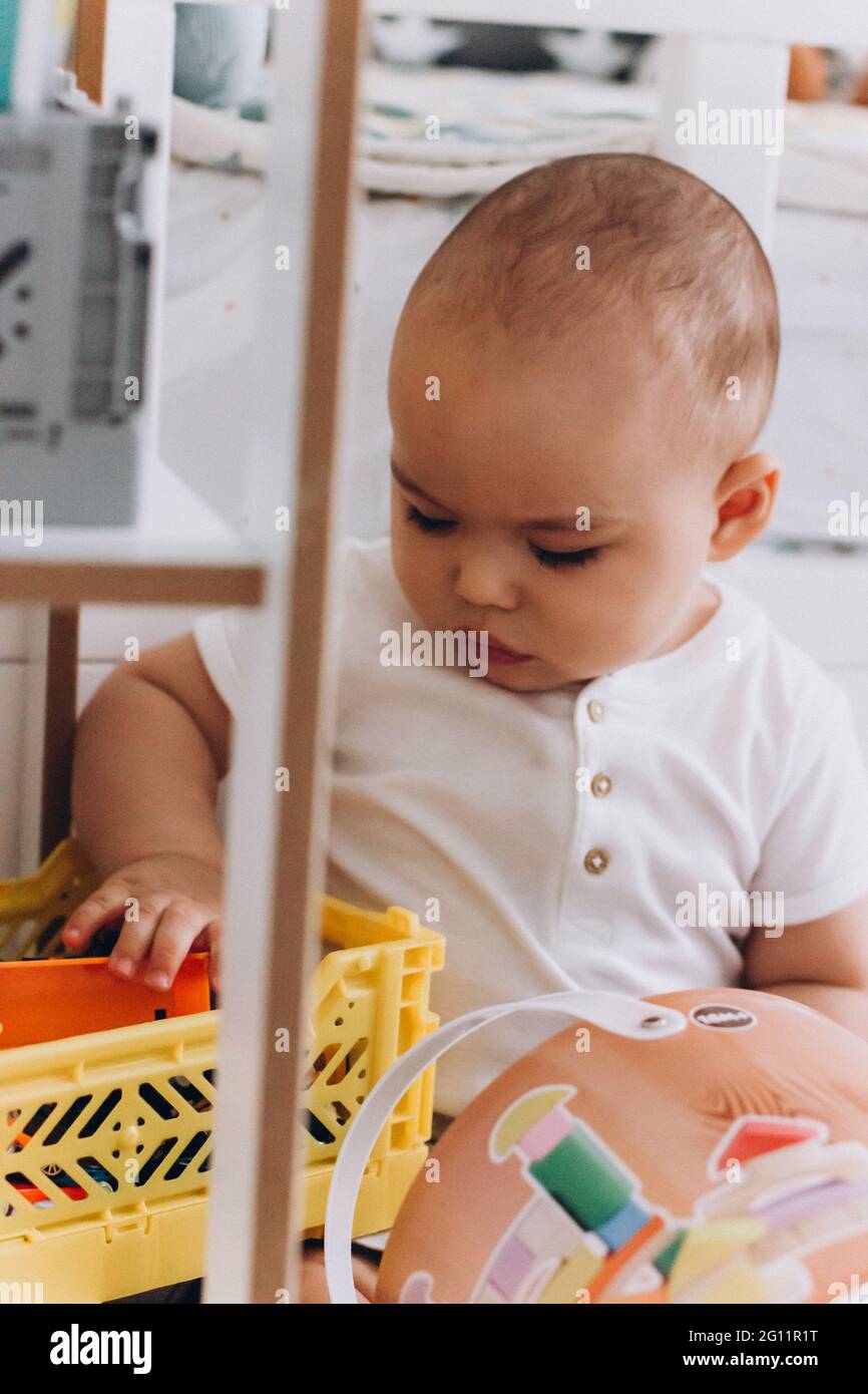 Piccolo bambino dolce che gioca sul pavimento in camera Foto Stock