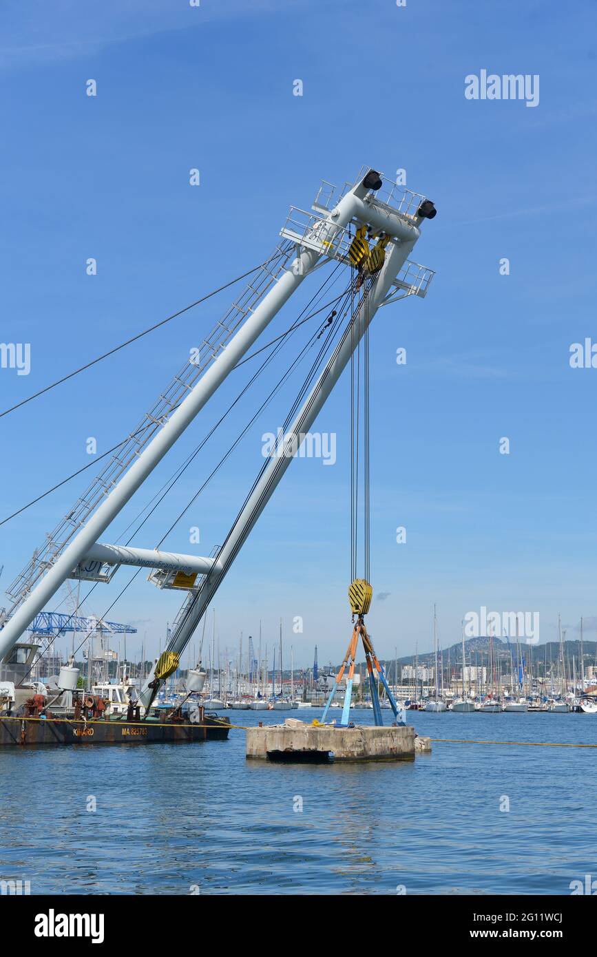 Azienda di lavori marittimi che rimuove le vecchie banchine di cemento dal porto turistico di Tolone con pontoni gru Foto Stock