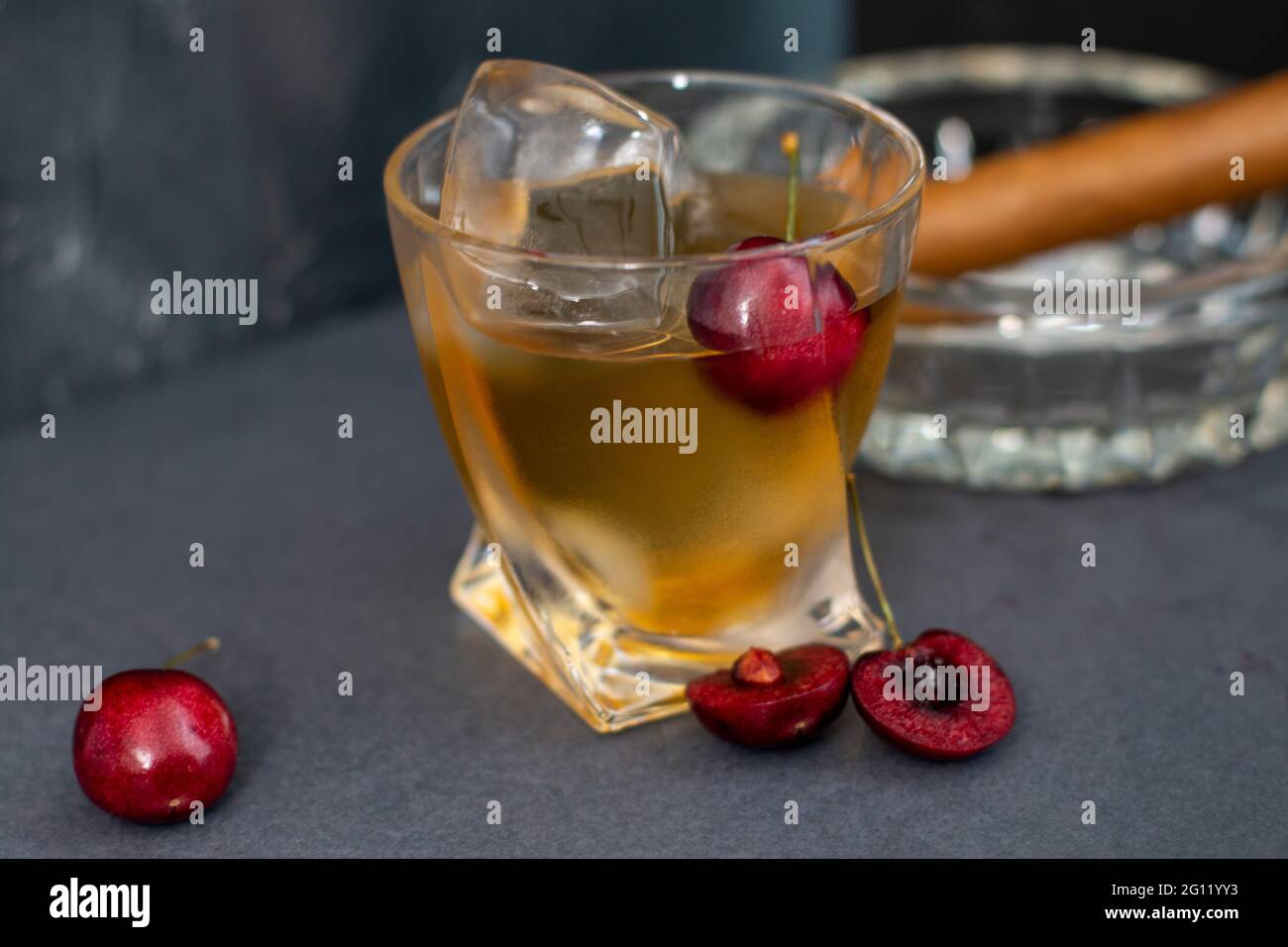 Un bel whisky di amarena in un vetro di rocce insolite con uno sfondo grigio ardesia. Foto Stock